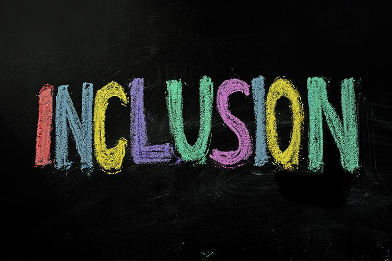 Inclusion written in multiple colors on a chalkboard