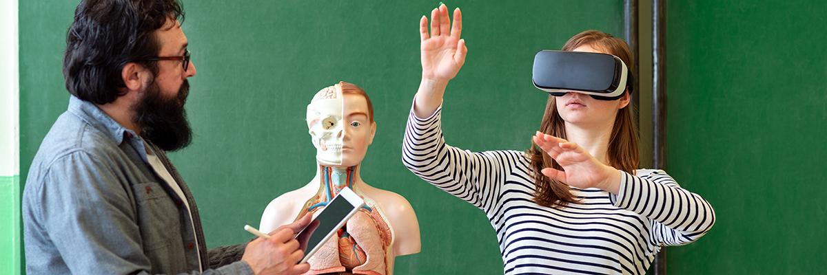 a teacher, a 3D anatomy model, and a student wearing a VR headset