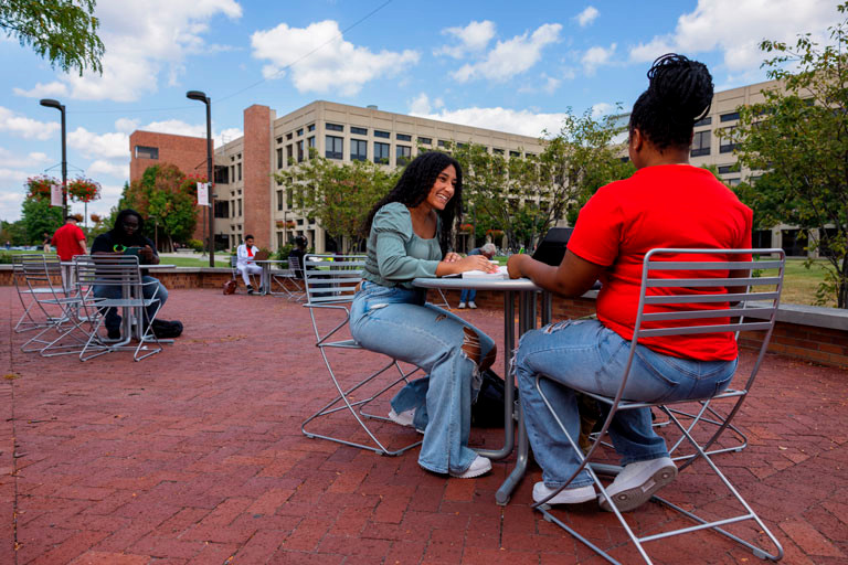 Students working at outside tables on the IU Indianapolis campus